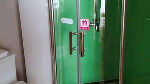 A bathroom with a toilet, a glass shower enclosure, and a green wall. - Greentree Inn Linxia Autonomous Prefecture Linxia Oxford River Avenue Express Hotel (Linxia)