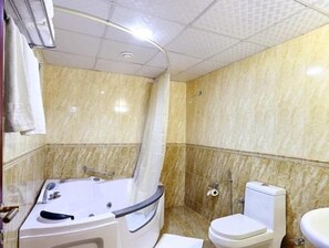 A bathroom with a bathtub, toilet, and sink. - Gulf Star Hotel Deira (Dubai)