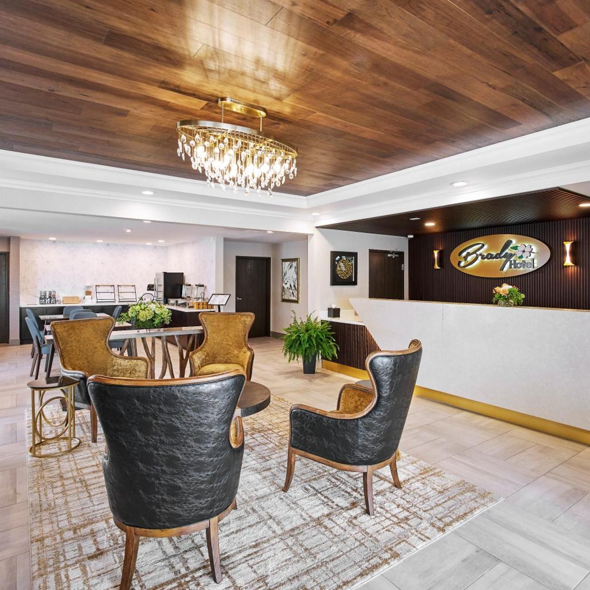 Un hall d’hôtel comprenant un comptoir d’accueil, un espace salon et un lustre.