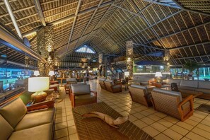 Een ruime lobby met hoge plafonds, comfortabele zitplaatsen en een groot raam met uitzicht.