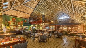 A spacious indoor dining area with high ceilings, multiple tables, and chairs. - Portobello Hotel Resort And Safari (Mangaratiba)