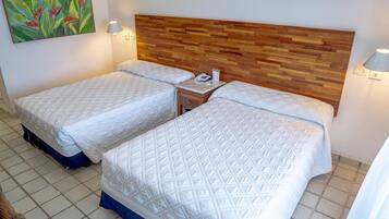 Habitación de hotel con dos camas, cabecero de madera, lámparas de noche y un cuadro en la pared.