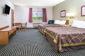 Ein Hotelzimmer mit einem Bett, einem Schreibtisch, einem Stuhl, einem Fernseher und einem Fenster mit Vorhängen.