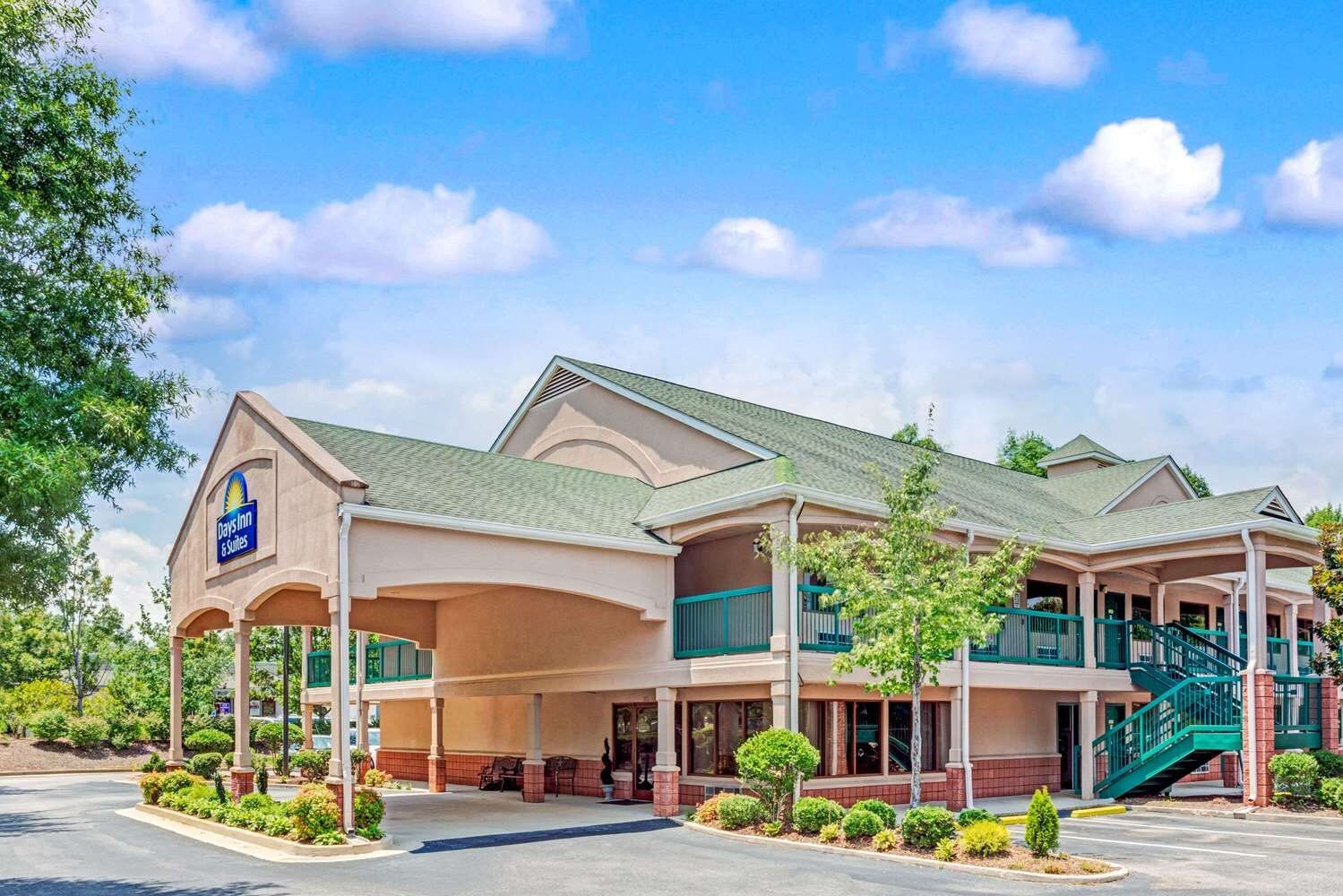A hotel with a large entrance, covered outdoor seating, and a staircase leading to the upper level.