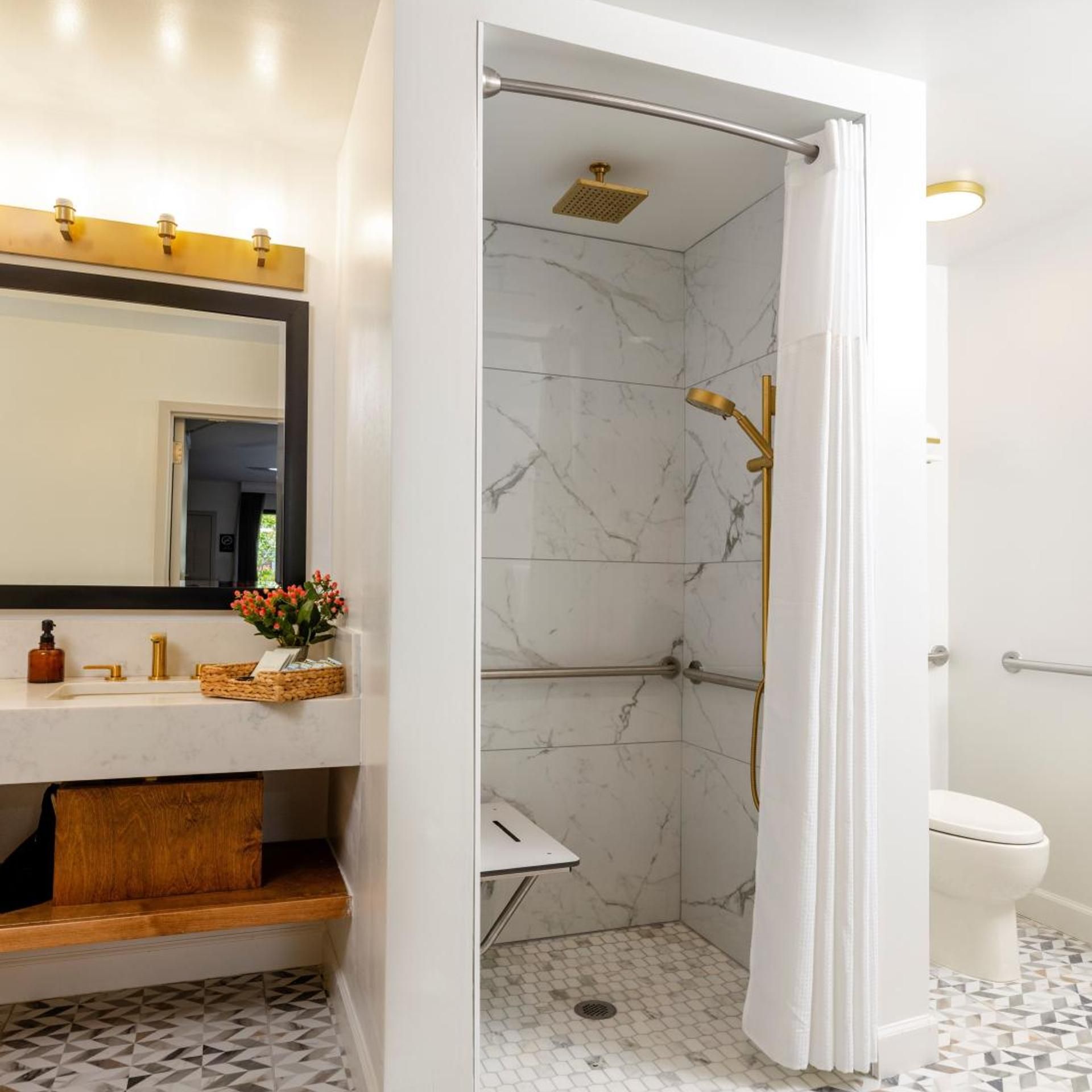 A bathroom with a shower, toilet, and a vanity with a mirror and sink.