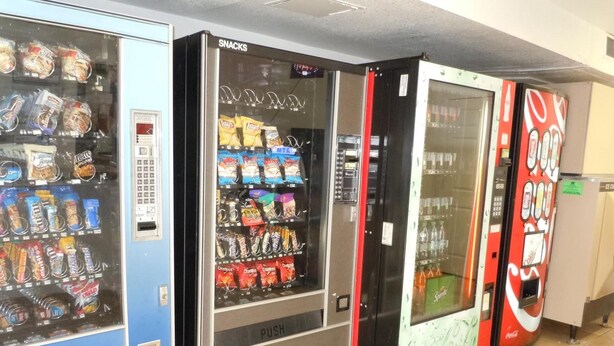 Ein Automatenbereich mit Snacks, Getränken und einer Coca-Cola-Maschine.