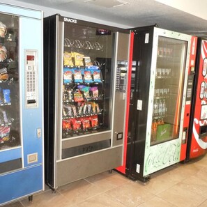 Una fila de máquinas expendedoras con aperitivos y bebidas.