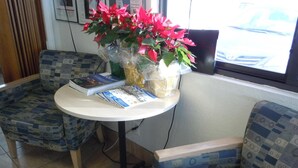 Eine Sitzecke mit gemusterten Stühlen, einem Tisch mit Zeitschriften und einer Vase mit Blumen.