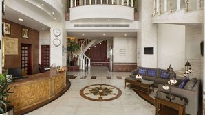 A spacious lobby with a reception desk, a staircase, and a seating area with a sofa and coffee table. - Super 8 By Wyndham Ridgecrest (Ridgecrest)