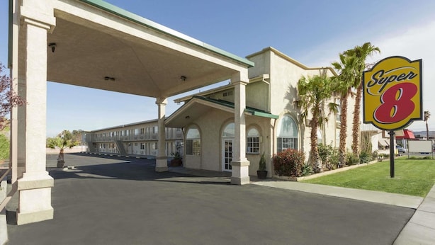 A Super 8 motel with a gas station, outdoor parking, and palm trees. - Super 8 By Wyndham Ridgecrest (Ridgecrest)