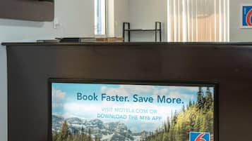 A reception desk with a digital screen displaying a booking message.