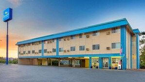 Un hotel de techo plano, con varias ventanas y un estacionamiento.