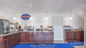 Una barra de desayuno con un letrero de Baymont, una cafetera y una máquina para hacer gofres.