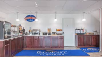 A breakfast bar with a Baymont sign, a coffee machine, and a waffle maker.
