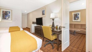 A hotel room with two beds, a desk with a chair, a television, a lamp, and a sofa. - Hotel Roseburg (Roseburg)