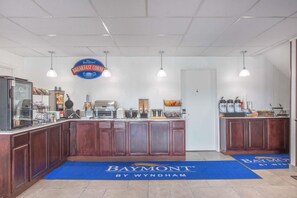 A breakfast counter with a Baymont sign, a coffee machine, and a fruit display. - Hotel Roseburg (Roseburg)