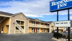 A motel with a sign reading 'RODEWAY INN' and 'GREAT LOW RATE.' - First Interstate Inn (Grand Junction)