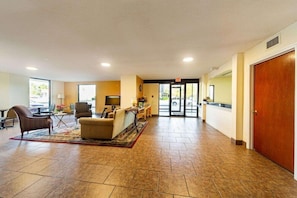 Eine geräumige Lobby mit einer Rezeption, einer Sitzecke und einem großen Fenster.