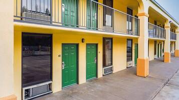 A row of yellow buildings with green doors and balconies.