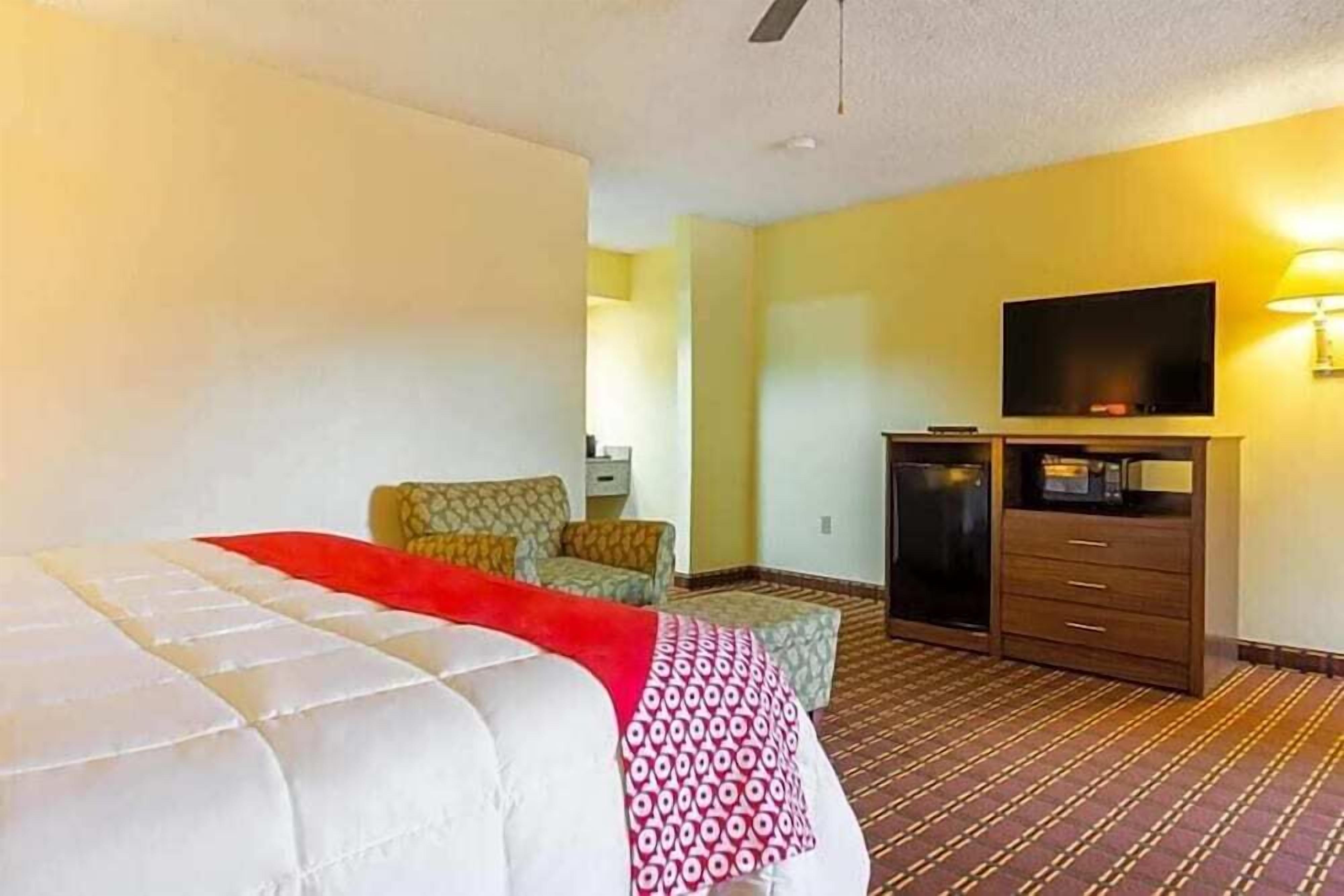 A hotel room with a bed, a television, a desk, and a chair.