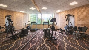 Une salle de remise en forme équipée de tapis de course, d’appareils elliptiques et de vélos d’appartement.