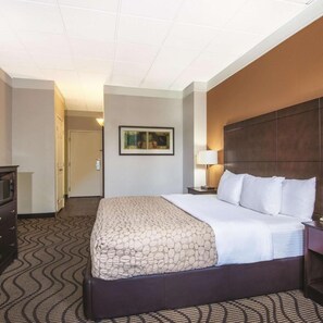 A hotel room with a large bed, a dresser, a nightstand, a lamp, and a framed picture on the wall. - La Quinta Inn & Suites by Wyndham Silverthorne - Summit Co (Silverthorne)