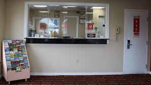 A reception desk with a glass partition, a telephone, and a red 'No Smoking' sign. - Econo Lodge Chesapeake Route 13 and I-464 (Chesapeake)