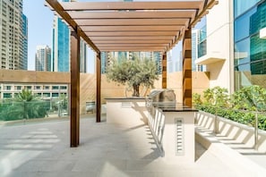 Ein moderner Außenbereich mit einer Pergola, Sitzgelegenheiten und einem Baum.
