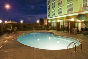 A swimming pool with a fence, chairs, and a building in the background. - Country Inn & Suites By Radisson Evansville IN (Evansville)