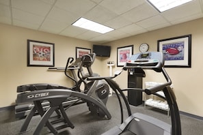 A fitness center with treadmills, a stationary bike, and a wall clock. - Country Inn & Suites By Radisson Evansville IN (Evansville)