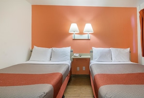 A hotel room with two beds, a nightstand with a phone, and two wall-mounted lamps. - Motel6 Topeka, KS - Northwest (Topeka)