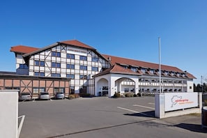 A hotel with a traditional European architectural style, featuring a prominent entrance and a parking area. - Lindner Hotel Nurburgring Motorsport, Part of JDV by Hyatt (Nuerburg)