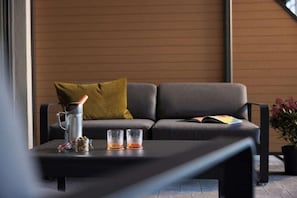 A modern living room with a sofa, a coffee table, and a potted plant. - Lindner Hotel Nurburgring Motorsport, Part of JDV by Hyatt (Nuerburg)