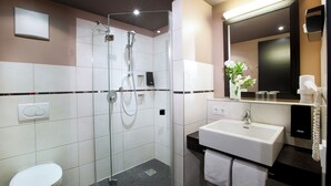 A modern bathroom with a glass-enclosed shower, a white sink, and a toilet. - Lindner Hotel Nurburgring Motorsport, Part of JDV by Hyatt (Nuerburg)