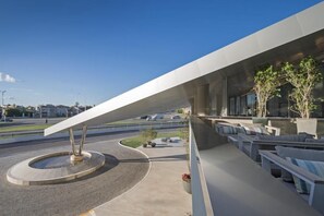 A modern outdoor seating area with a curved bench and a central sculptural element. - Mercure Santa Rosa (Santa Rosa)