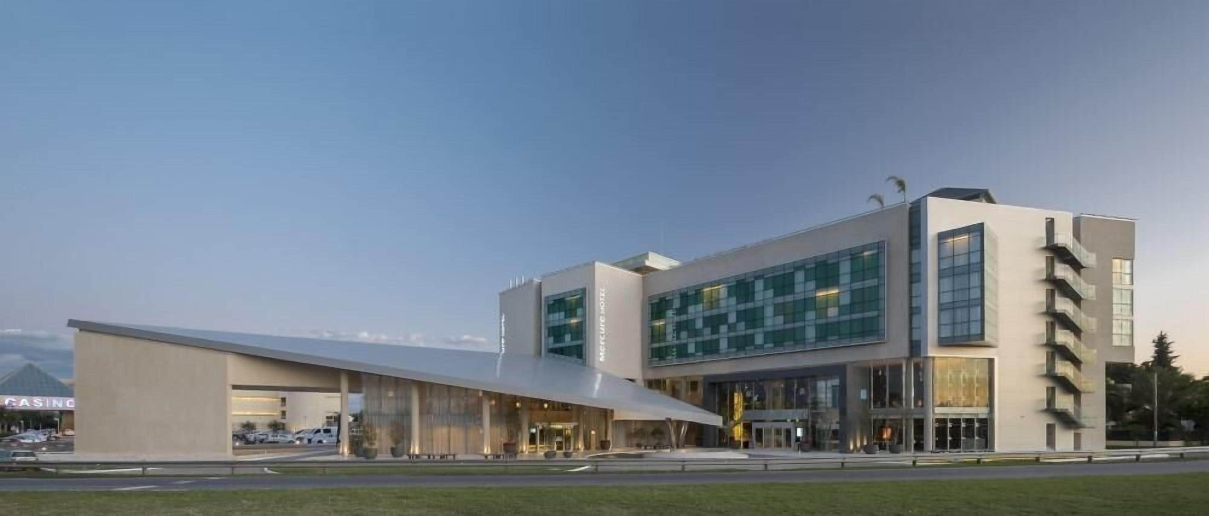 A modern building with a flat roof, large windows, and a covered entrance.