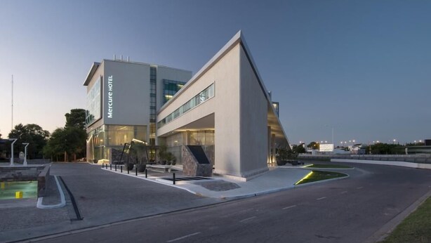 Un hotel moderno con una fachada de vidrio destacada y una estructura triangular distintiva.