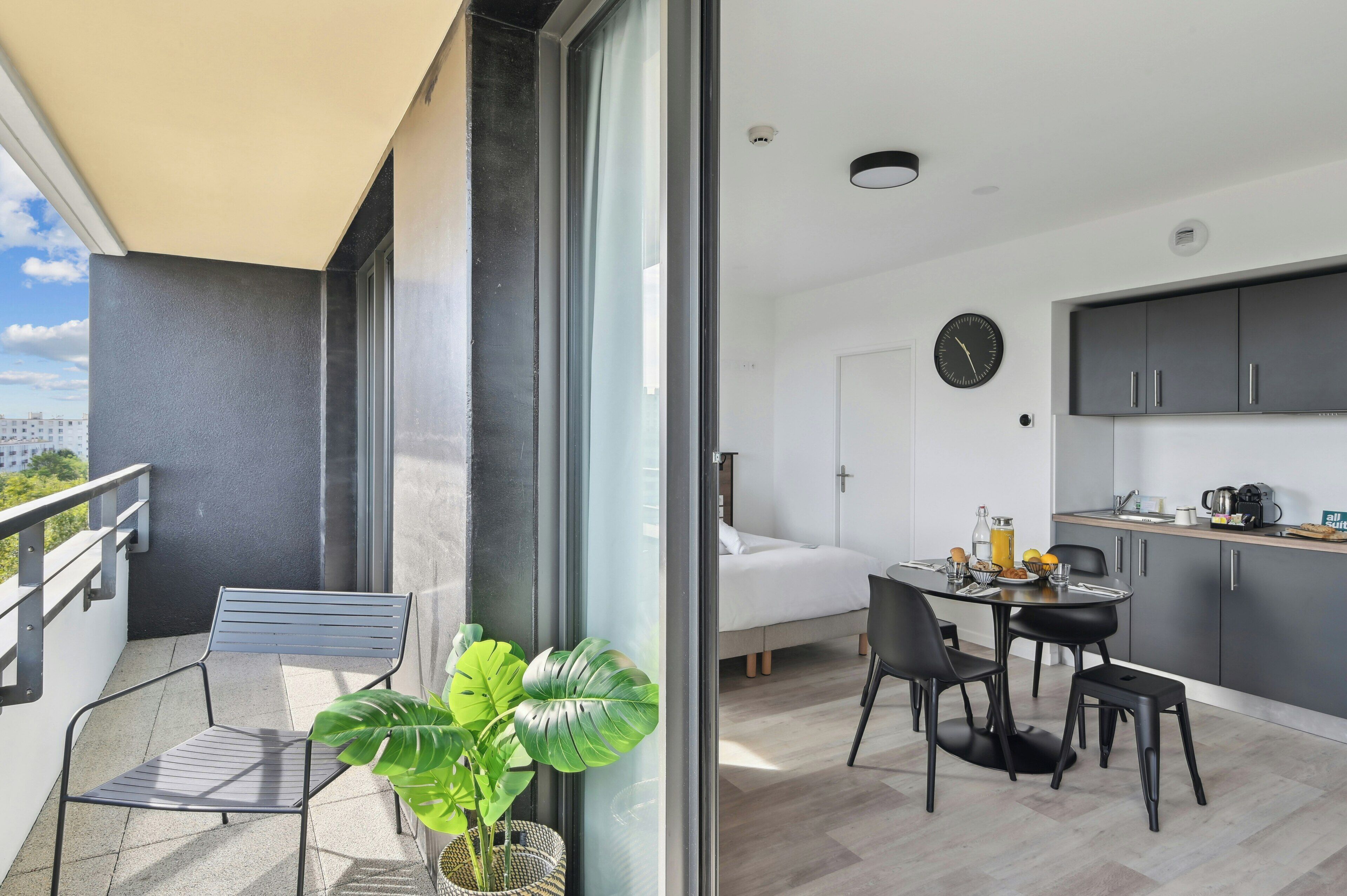Un apartamento moderno con balcón, comedor y cocina.