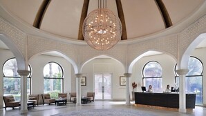 A spacious lobby with a large chandelier, arched ceilings, and a reception desk. - Dubai Creek Club Villas (Dubai)