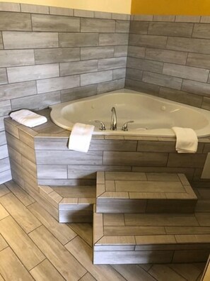 A bathroom with a freestanding bathtub, a sink, and a set of wooden steps leading to the tub. - Unadilla/perry Near I-75 (Unadilla)