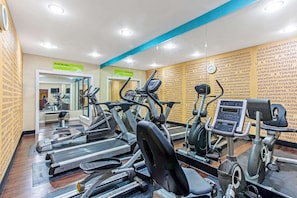 A gym with multiple treadmills, ellipticals, and a mirrored wall. - Manassas Hotel (Manassas)