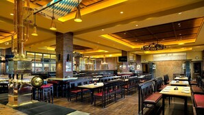 A spacious restaurant with high ceilings, exposed brick walls, and a variety of seating arrangements. - Kempinski Hotel Changsha (Changsha)