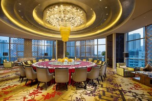 A spacious conference room with a round table, high ceilings, and large windows offering city views. - Kempinski Hotel Changsha (Changsha)