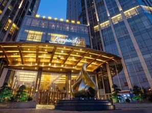 A modern hotel entrance with a prominent sign, a sculpture, and a glass facade. - Kempinski Hotel Changsha (Changsha)