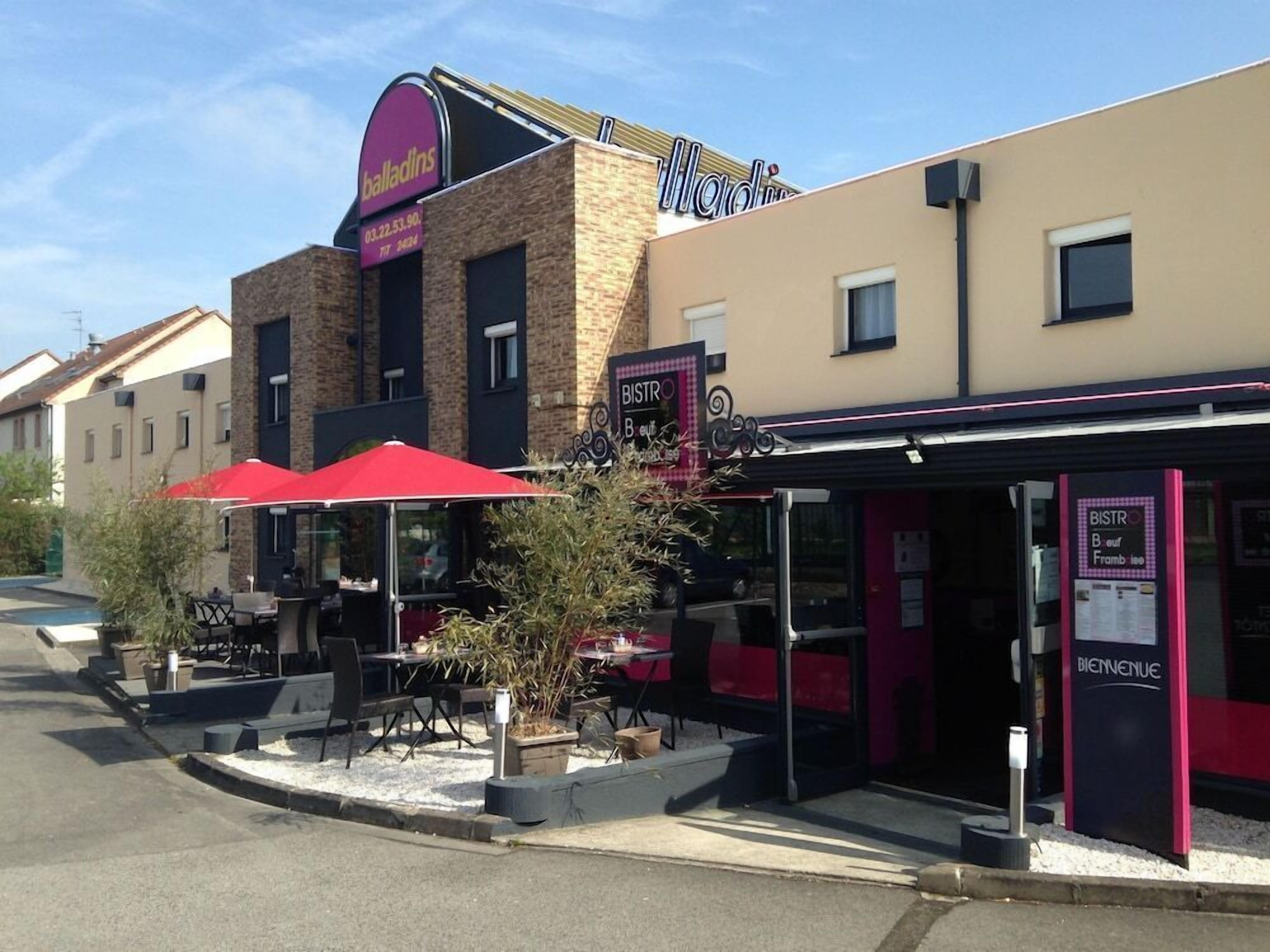 A restaurant with outdoor seating, a sign for 'Balladins,' and a 'BISTRO' sign.