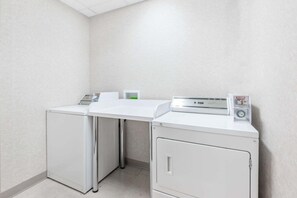 A laundry area with a washing machine, dryer, and a utility cabinet. - Red Deer City Centre (Red Deer)