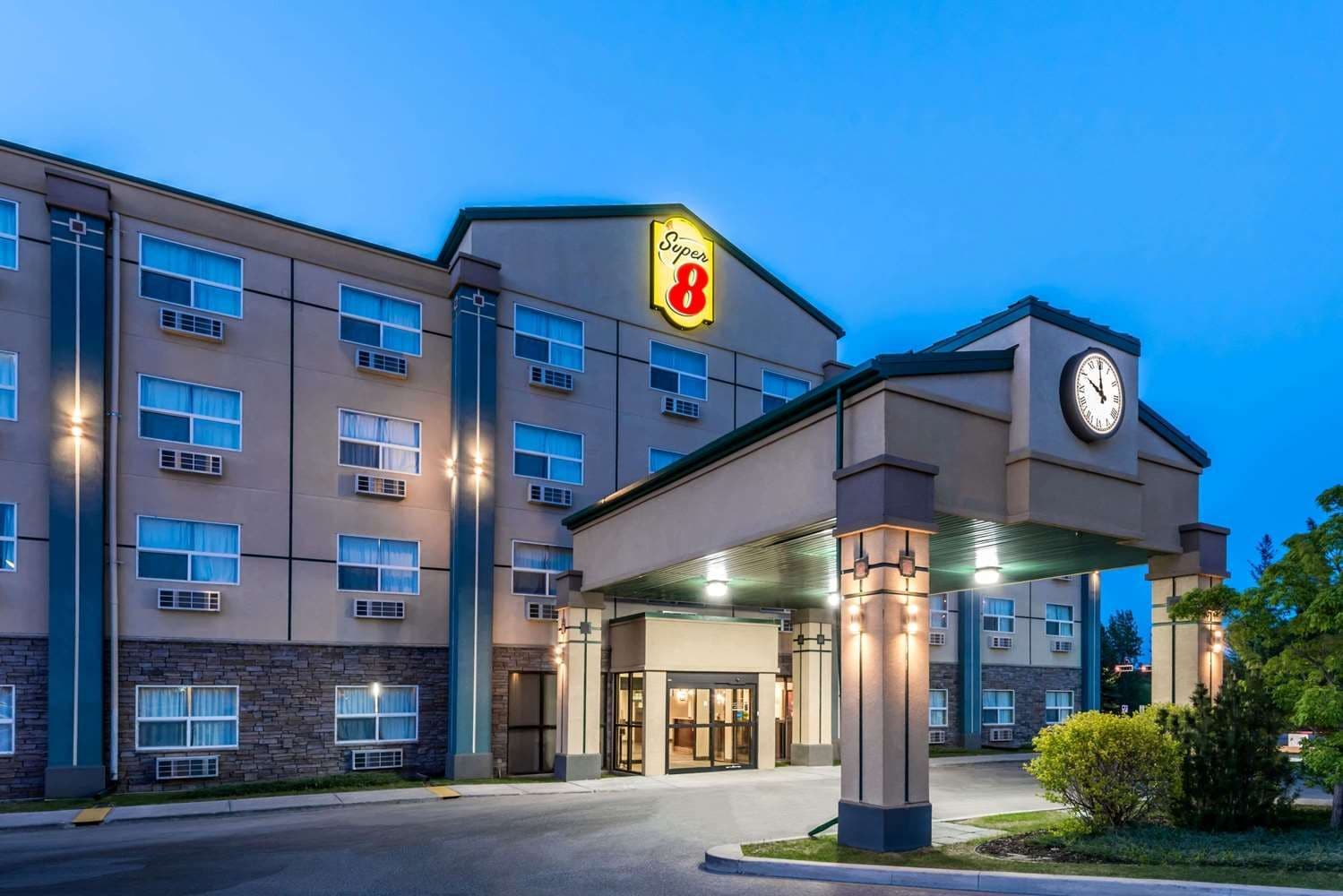 Un hôtel de la chaîne Super 8 doté d’une tour avec horloge, de nombreuses fenêtres et d’une entrée abritée.
