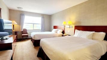 Une chambre d’hôtel avec deux lits, une télévision, un bureau et une chaise.