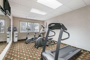 A fitness room with exercise equipment including a treadmill, stationary bikes, and a water dispenser. - Red Deer City Centre (Red Deer)