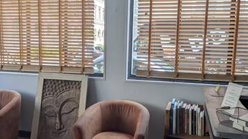 Une pièce comprenant un échiquier, une œuvre d’art encadrée, une chaise et une bibliothèque.